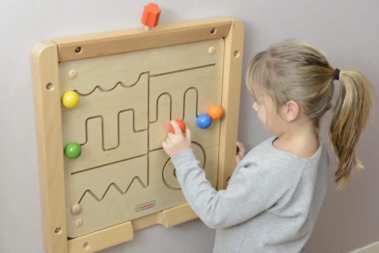 Widok z góry na tory labiryntu Montessori — przesuwne koraliki i trasy do ćwiczeń manualnych