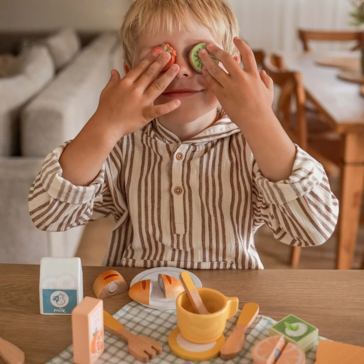 Dziecko bawi się zestawem TOOKY TOY — układanie kanapek i nauka krojenia na rzepy podczas zabawy