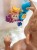 Widoczna naklejka z oznaczeniami bezpieczeństwa i grafika producenta WOOPIE BABY na opakowaniu