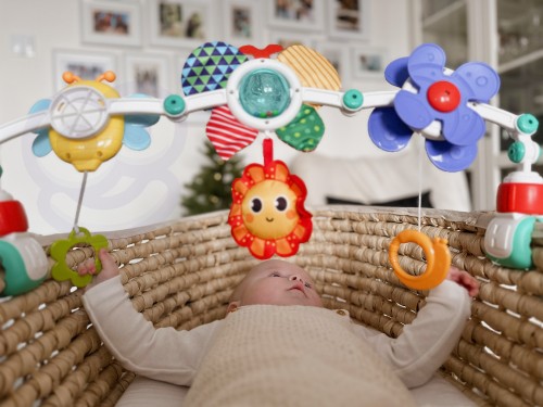 Widok z boku pałąka WOOPIE BABY 88 zamocowanego do łóżeczka, wiszące zabawki w lekkim ruchu