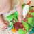 Książeczka w dłoni dziecka — pokaz rozmiaru i elastyczności materiału WOOPIE BABY podczas zabawy