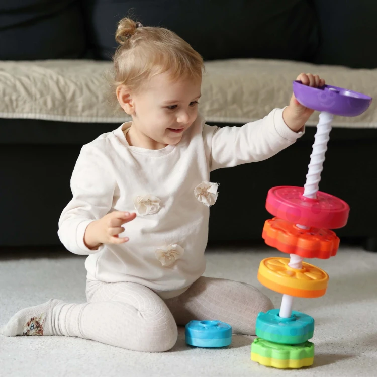 Zbliżenie na kręcące elementy piramidki WOOPIE BABY — barwne kółka i miniaturowe zwierzątka z detalami