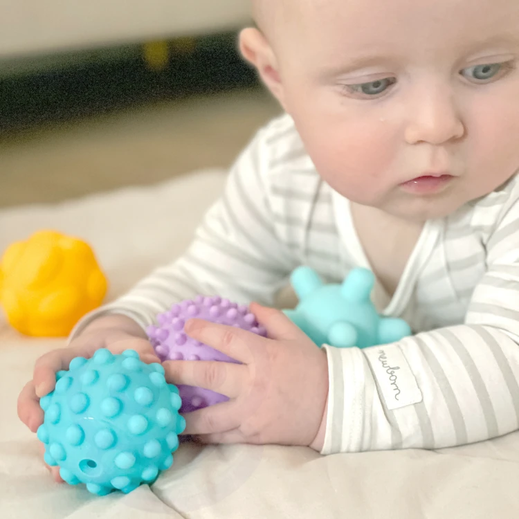 Widok sześciu elementów klocków sensorycznych WOOPIE BABY ułożonych obok siebie, widoczne kolory i kształty