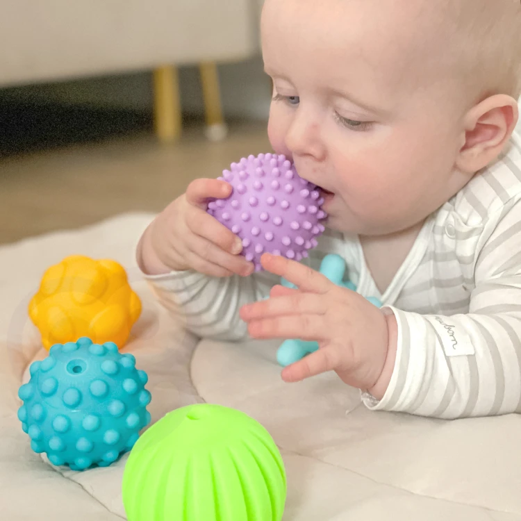 Maluch trzymający elementy WOOPIE BABY — demonstracja chwytu i zabawy sensorycznej jednym klockiem