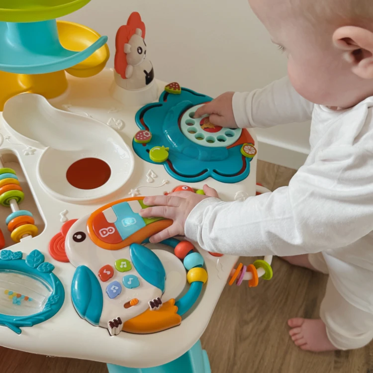 Dziecko bawiące się przy WOOPIE BABY — pokaz zastosowania stolika edukacyjnego i ergonomii miejsca zabawy