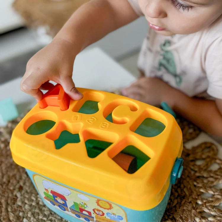 Kompozycja wszystkich elementów zestawu — skrzynka, klocki i litery sorter 2w1 WOOPIE BABY widoczne razem