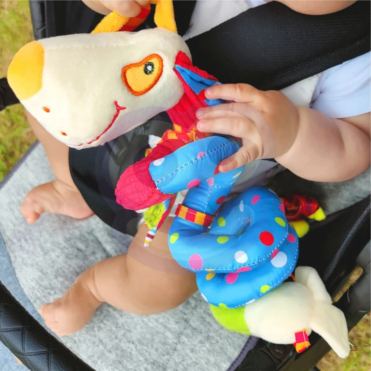 Ujęcie z boku pokazujące spiralną konstrukcję zawieszki WOOPIE BABY oraz wiszące zabawki