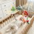 Zbliżenie na wiszące zabawki pałąka WOOPIE BABY — miękkie kształty i detale bezpieczne dla niemowląt
