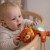 Lampka na stoliku nocnym — miś-projektor WOOPIE BABY ustawiony przy łóżku, delikatne rozproszone światło