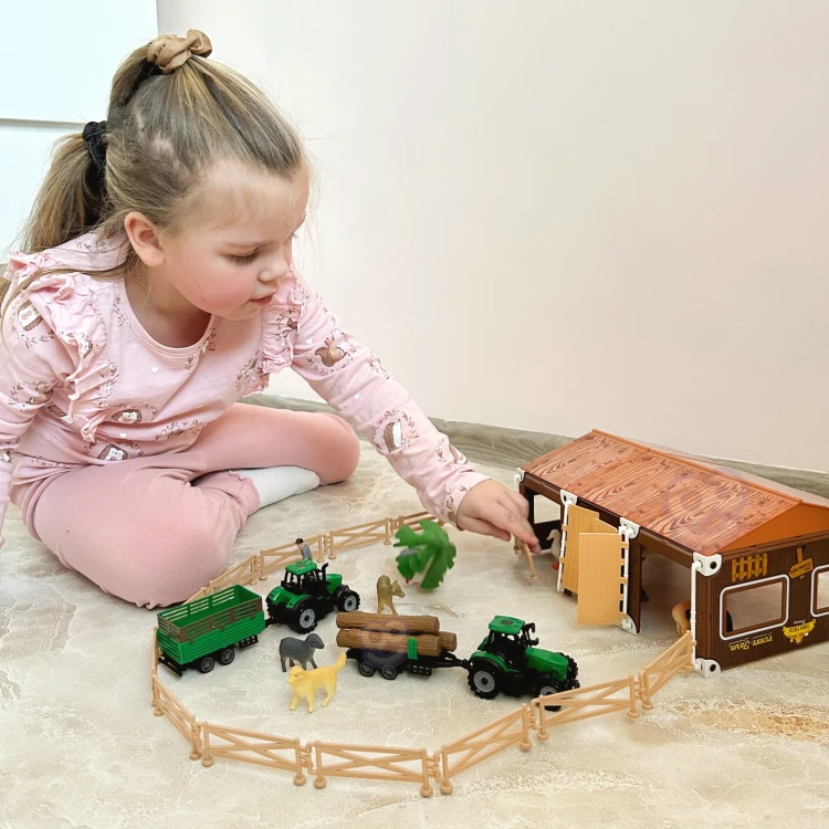 Dziecko trzyma w dłoniach figurki Mały Farmer XL — pokaz skali i naturalnego zastosowania zestawu podczas zabawy
