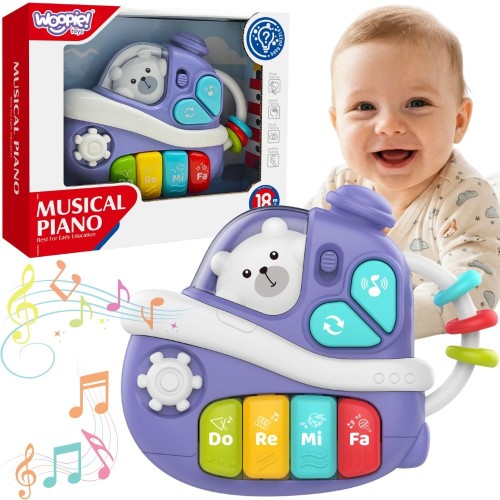 Interaktywne muzyczne pianinko WOOPIE BABY w kształcie fioletowego statku z białym misiem w okienku