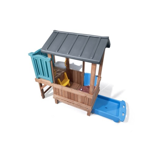 Widok z boku na domek STEP2 — wejście, poręcze i fragment zjeżdżalni w naturalnych kolorach
