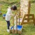 Perspektywa z boku placu zabaw wodnego — rury, złącza i pojemnik na wodę widoczne w naturalnym świetle