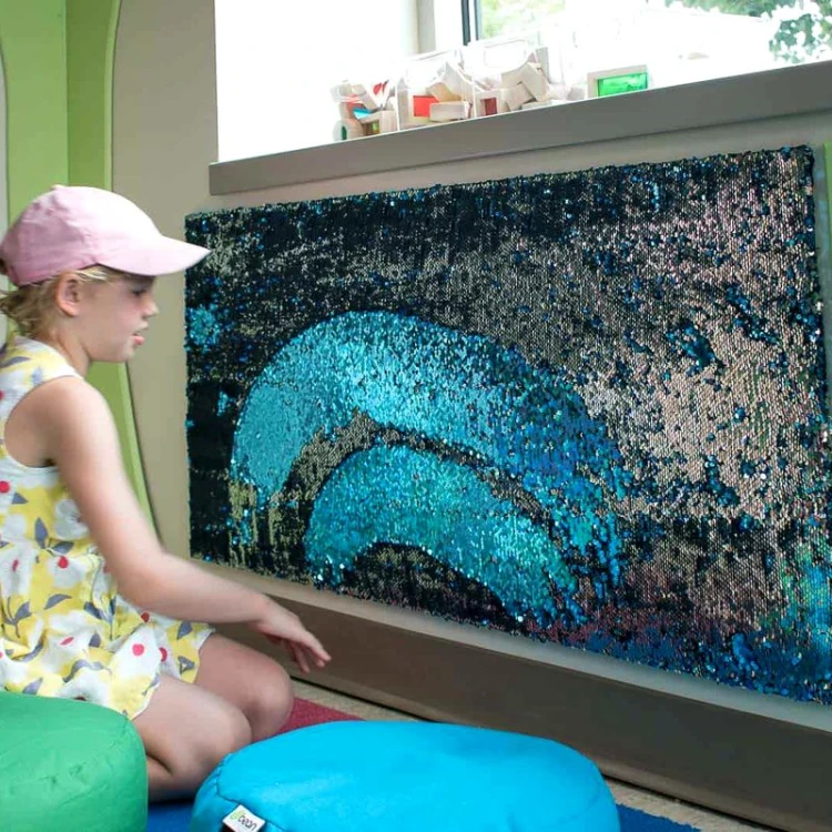 Tablica cekinowa w aranżacji sali terapeutycznej, przykład montażu pionowego na ścianie