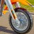Dziecko siedzące na motocyklu FEBER — dłonie na kierownicy i włączony przedni reflektor