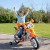 Zbliżenie na dekoracyjne naklejki i logo FEBER na baku pomarańczowego motocykla