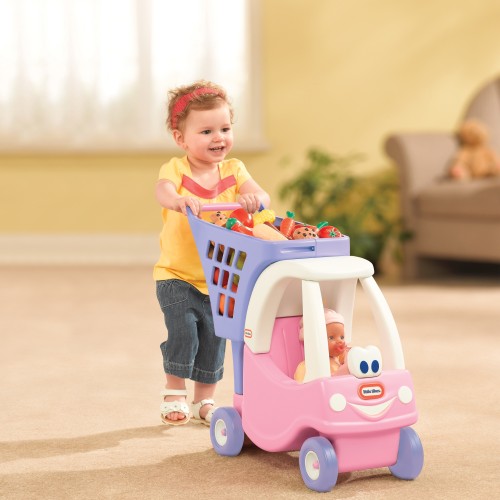 Widok z profilu wózka Cozy Coupe Little Tikes — różowa karoseria, kierownica i praktyczna półka na drobiazgi.