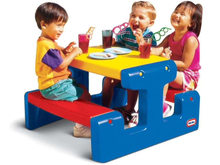 Stolik piknikowy Little tikes ustawiony w ogrodzie — dzieci korzystają z niebieskiego blatu podczas zabawy