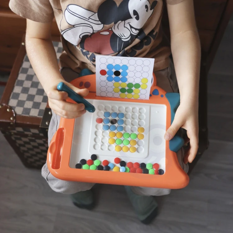 Magnetyczne akcesoria przy tablicy WOOPIE — kreda, gąbka i kolorowe magnesy ułożone obok