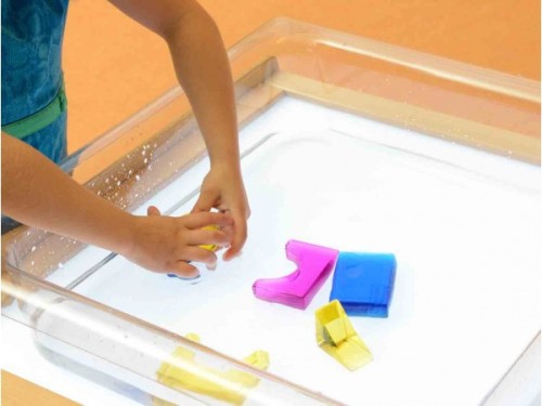 Boczny kadr pojemnika MASTERKIDZ 55 — przezroczyste ścianki akrylowe i widoczne wgłębienie na piasek lub wodę