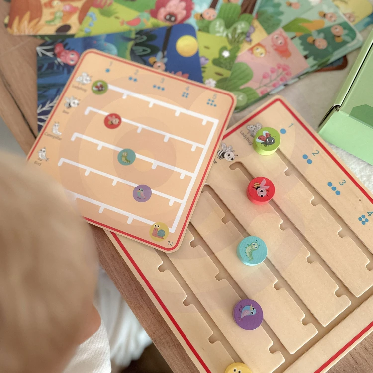 Perspektywa boczna planszy TOOKY TOY — elementy do nauki liczenia ułożone w równych rzędach