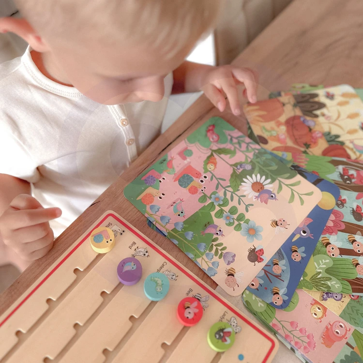 Widok z góry na elementy gry TOOKY TOY — plansza z figurkami i przegródkami ułatwiającymi przechowywanie