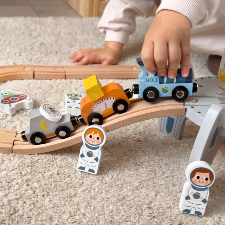 Kolorowy wagonik z serii Kosmicznej kolejki — detal kół i zaczepów, fragment torów TOOKY TOY