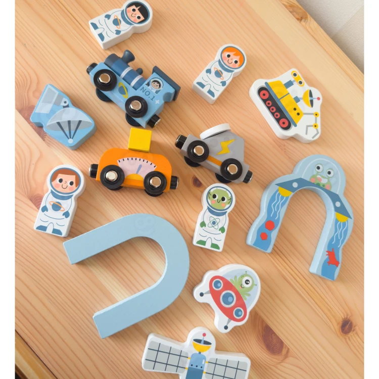 Dziecko bawi się drewnianą kolejką Kosmiczną TOOKY TOY — pociąg na torach w dynamicznym ujęciu
