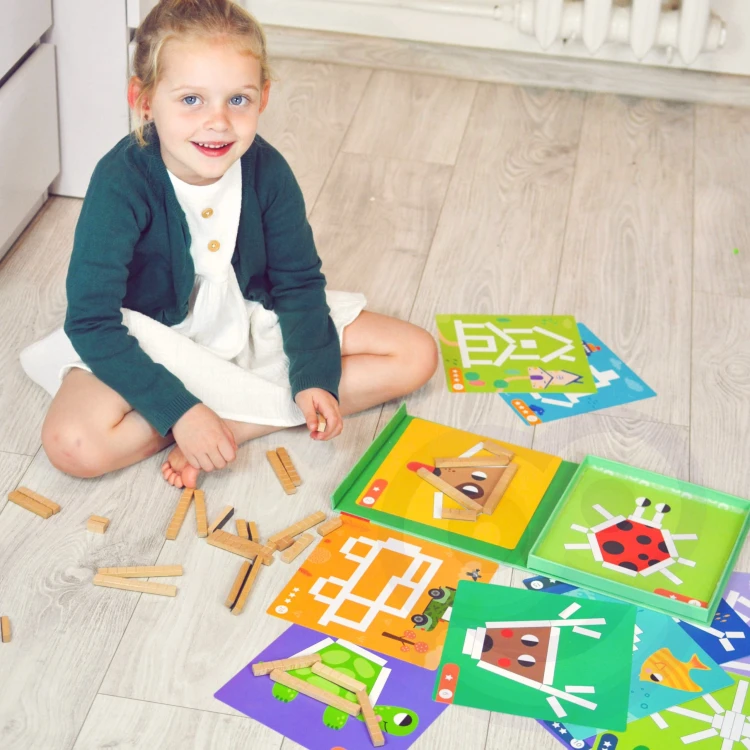 Instrukcja obok rozłożonych elementów TOOKY TOY — przykład wzoru do odtworzenia i inspiracje do zabaw logicznych
