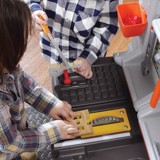 Widok z boku warsztatu STEP2 — szeroki blat roboczy z uchwytami i miejscem na akcesoria