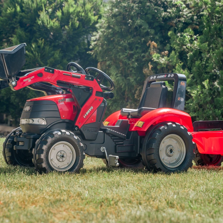 Perspektywa boczna traktora Case FALK z podpiętą przyczepką — widoczny pedał, osłona kół i ergonomiczne siedzenie