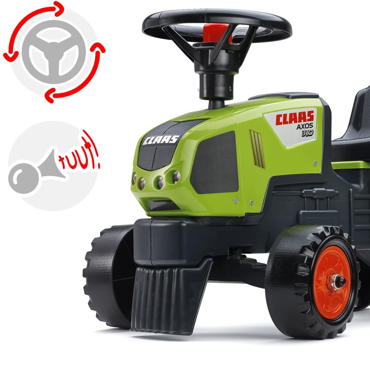 Dziecko siedzące na traktorku Baby Claas w realistycznej scenie zabawy, widać przyczepkę i kierownicę