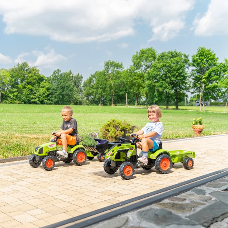 Zbliżenie na kabinę i kierownicę traktora Claas — widoczne pedały oraz wykończenia marki FALK