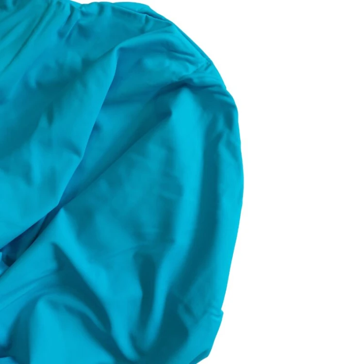 Detal materiału lycra tunelu sensorycznego i fragment etykiety z zaleceniami użytkowania