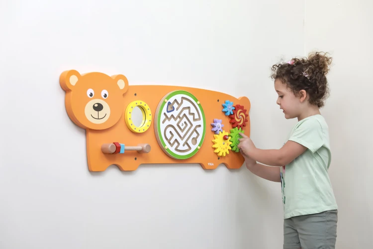 Ręce dziecka bawiące się tablicą sensoryczną VIGA Miś — chwytanie, przesuwanie i poznawanie elementów manipulacyjnych w użyciu