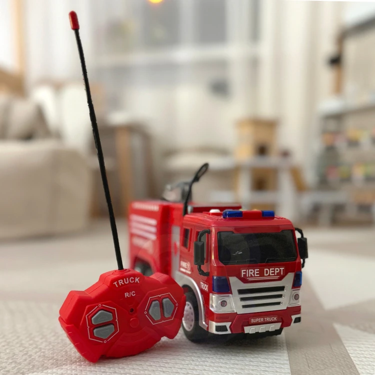 Zbliżenie na pilot sterujący wozem WOOPIE — przyciski, antena i ergonomiczny kształt uchwytu do zabawy