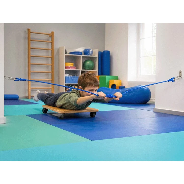 Detale zakończenia liny: karabińczyk i sposób połączenia, pokazane na tle podłogi sali terapeutycznej