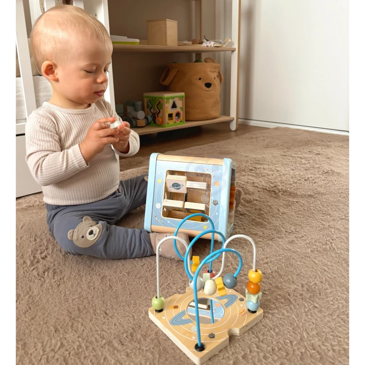 TOOKY TOY — detal labiryntu z koralikami i kolorowymi szynami na górnej ściance kostki