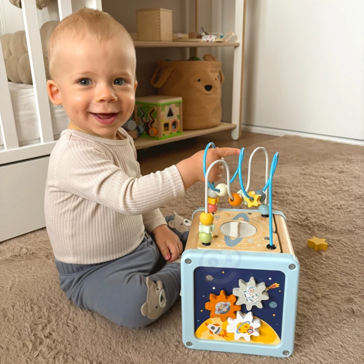Widok boczny kostki aktywności TOOKY TOY — panel z obrotowymi kołami i przekładniami