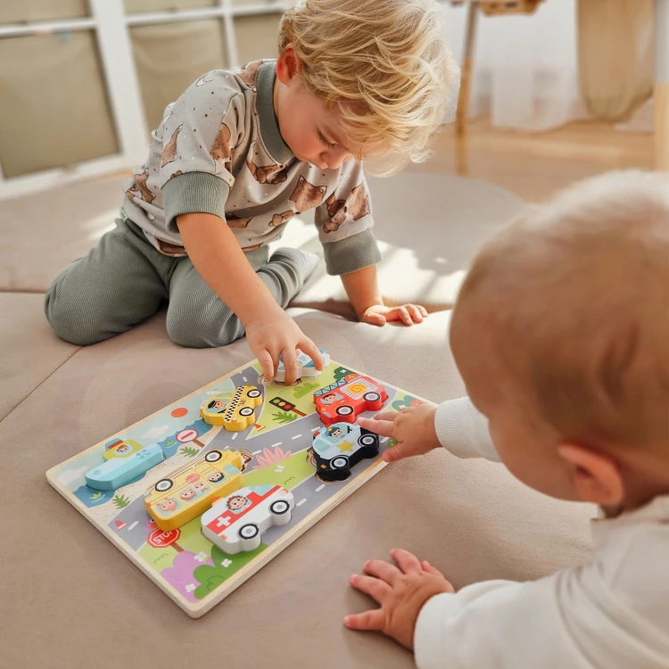 Ręka dziecka wkłada kształt samochodu — praktyczne dopasowywanie elementów puzzle Montessori TOOKY TOY