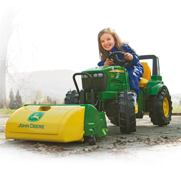 Rolly Toys — boczny profil FarmTrac z widocznymi pedałami, kołem i ergonomicznym siedzeniem, ujęcie z boku
