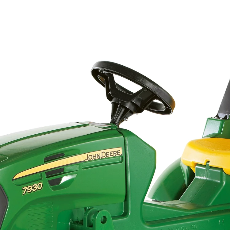 Dziecko prowadzi Rolly Toys FarmTrac na pedały — zabawa na podwórku, widoczne pedały, kierownica i solidna rama