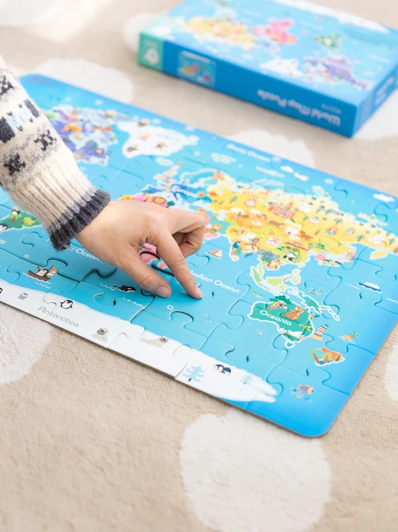 Puzzle Mapa Świata 50 — rozłożone elementy na stole, pokazane kształty wysp i linii brzegowych