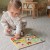 Dziecko dopasowujące element do planszy — edukacyjna zabawa przy puzzlach z pinezkami WOOPIE GREEN