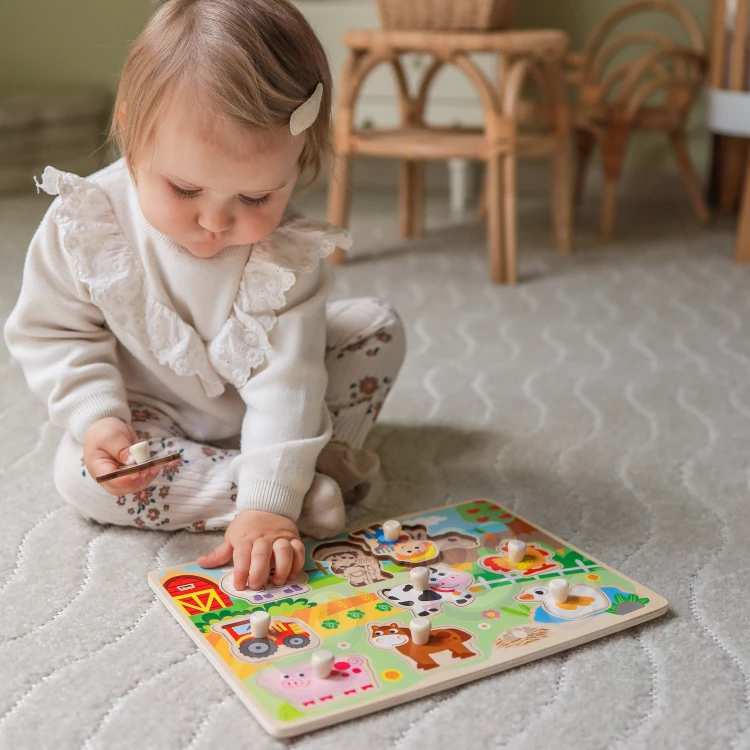 Dziecko dopasowujące element do planszy — edukacyjna zabawa przy puzzlach z pinezkami WOOPIE GREEN