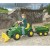 Kompozycja z dużej perspektywy: przyczepa Rolly Toys RollyHalfpipe John Deere w naturalnym otoczeniu