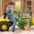 Boczny widok koparki John Deere RollyBackhoe — kabina, kierownica i wygodne siedzisko dla dziecka