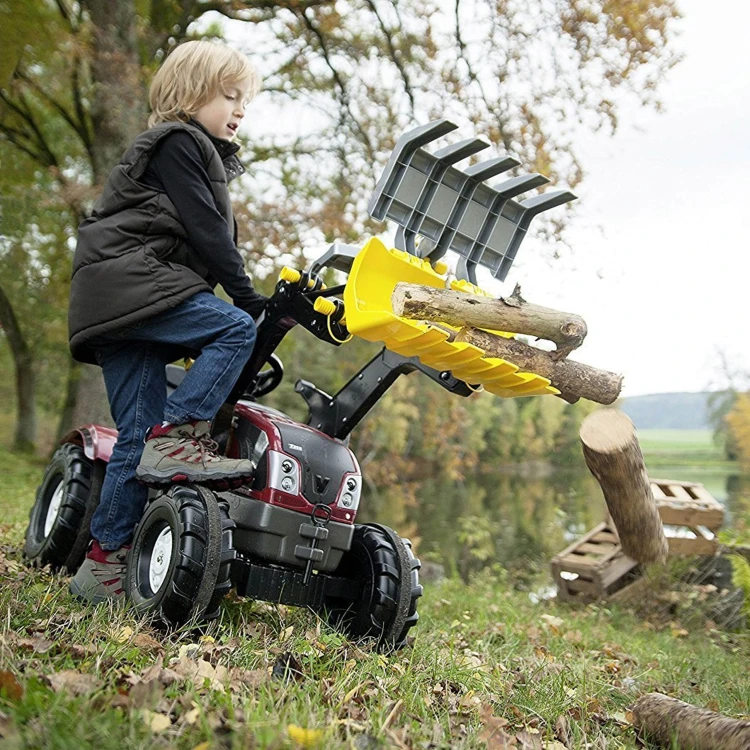 Elementy montażowe i łączenia łyżki do traktora Rolly Toys na tle pojazdu — detale metalowe i śruby