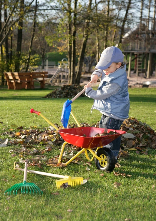 Taczka dla dzieci Rolly Toys ustawiona na trawie — widok wnętrza kuwetki i mocowania koła
