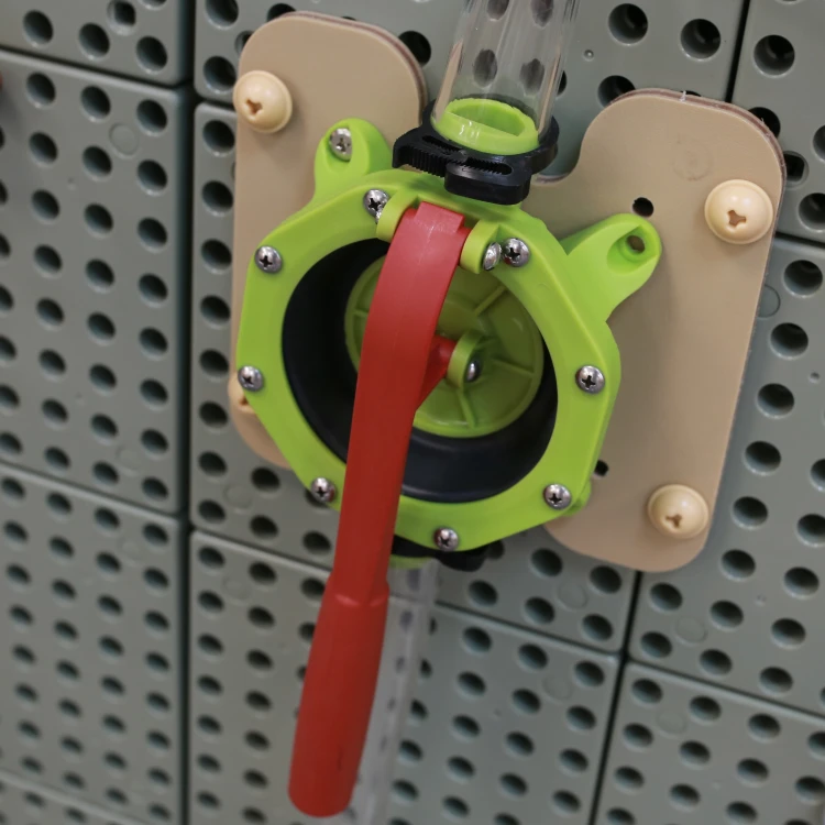 Fragment tablicy STEM WALL z przymocowaną pompą wodną i rurkami — element zestawu MASTERKIDZ do zabaw edukacyjnych